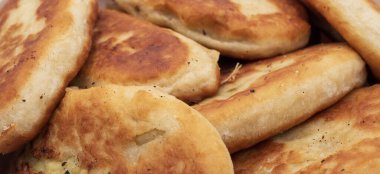 Bir kaseye istiflenmiş kızarmış hamur tatlısı yakın çekim. Beyaz arka planda doğal dokuyla izole edilmiş ev yapımı geleneksel yemekler..