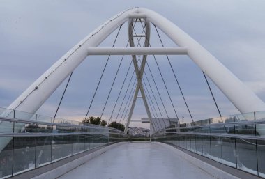 Atina, Yunanistan 'da beyaz çelik kemerli ve cam parmaklıklı yaya köprüsü