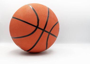 Beyaz arka planda izole edilmiş turuncu basketbol topu. Kapalı görünüm lastik dokuyu ve dikişleri gösteriyor, spor ve fitness kavramları için uygun.