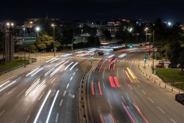 Yunanistan 'ın Atina kentindeki çok şeritli bir yolda gece trafiğinin uzun pozlu görüntüleri ışık yolları oluşturuyor. Kentsel ulaşım, hareket, modern şehir altyapısı.