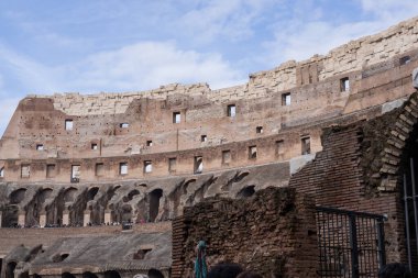 Kolezyumun içinde kavisli kemerler, tuğlalar ve yıpranmış taşlar var. Popüler turizm ve kültür mirası sitesi.