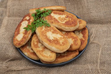 Tabakta çıtır çıtır patates kızartmalı taze patates turtası. Çuval bezi arka planında geleneksel kızarmış hamur işleri, konforlu yemekleri, ev yemeklerini ve klasik mutfağı temsil eder..