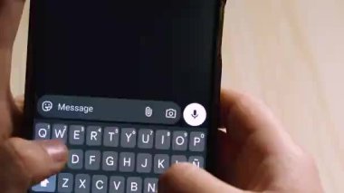 Mesajlaşma uygulamasında Merci 'yi yazarken akıllı telefonu tutan ellerin yakın çekimi. Minnettarlık kavramı, Fransızca dili, dijital iletişim ve modern teknoloji.