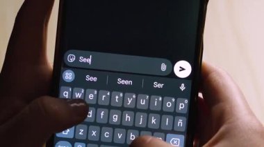 Akıllı telefonu tutan ellerin yakın çekimi, dijital bir klavyeye arkadaşça bir veda mesajı yazmak. Tahmini metin çubuğunda 