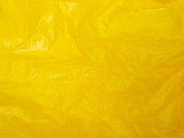 Yellow crumpled plastic bag texture background. Real High-Density Polyethylene shopping bag. HDPE shopper texture