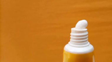 Beyaz Göz Kremi dokusu Sarı Arkaplanda Tüp 'ten Sıkıştırıldı, Cilt Yakın