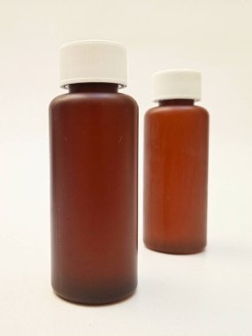 Beyaz arka planda izole edilmiş kehribar plastik şişeler ilaç, şurup, gerekli yağlar ve kozmetik ürünler için kahverengi plastik şişeler.