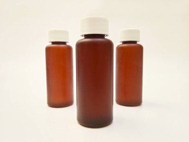 Beyaz arka planda izole edilmiş kehribar plastik şişeler ilaç, şurup, gerekli yağlar ve kozmetik ürünler için kahverengi plastik şişeler.