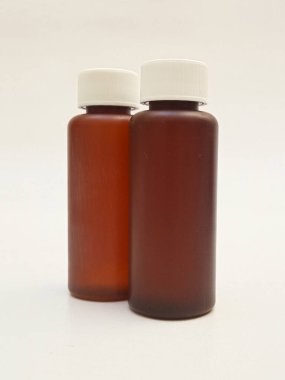 Beyaz arka planda izole edilmiş kehribar plastik şişeler ilaç, şurup, gerekli yağlar ve kozmetik ürünler için kahverengi plastik şişeler.
