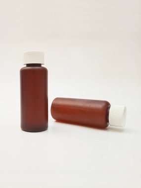 Beyaz arka planda izole edilmiş kehribar plastik şişeler ilaç, şurup, gerekli yağlar ve kozmetik ürünler için kahverengi plastik şişeler.