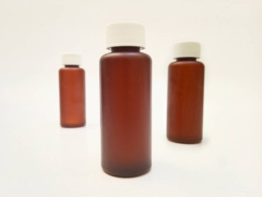 Beyaz arka planda izole edilmiş kehribar plastik şişeler ilaç, şurup, gerekli yağlar ve kozmetik ürünler için kahverengi plastik şişeler.