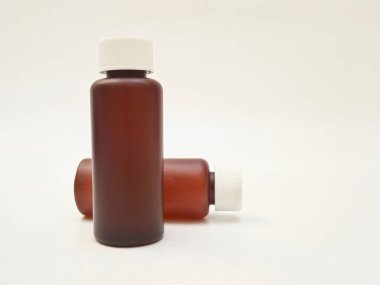 Beyaz arka planda izole edilmiş kehribar plastik şişeler ilaç, şurup, gerekli yağlar ve kozmetik ürünler için kahverengi plastik şişeler.