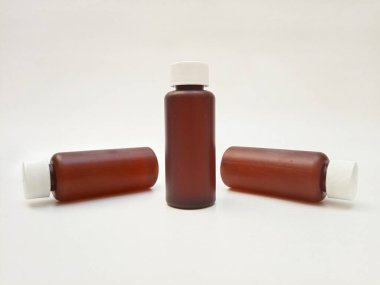 Beyaz arka planda izole edilmiş kehribar plastik şişeler ilaç, şurup, gerekli yağlar ve kozmetik ürünler için kahverengi plastik şişeler.