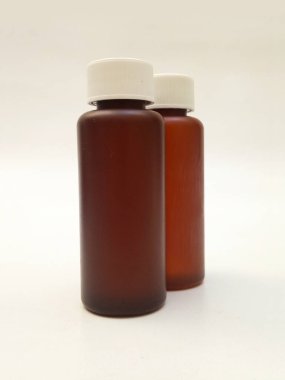 Beyaz arka planda izole edilmiş kehribar plastik şişeler ilaç, şurup, gerekli yağlar ve kozmetik ürünler için kahverengi plastik şişeler.