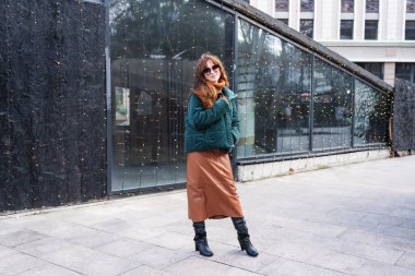 Neşeli kızıl saçlı bir kadın Tiflis, Georgia 'da Avrupa tarzı bir Noel pazarının büyülü atmosferinin tadını çıkarıyor..