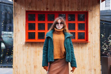 Neşeli kızıl saçlı bir kadın Tiflis, Georgia 'da Avrupa tarzı bir Noel pazarının büyülü atmosferinin tadını çıkarıyor..