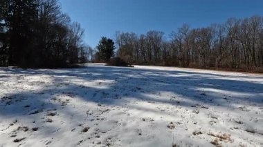 Güneşli Ocak gününde parkta karlı ve buzlu tepe