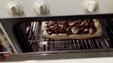 Berkeley Heights, NJ, ABD - 01-18-2022: fırında sosis ve brokoli ile ev yapımı pizza pişirme