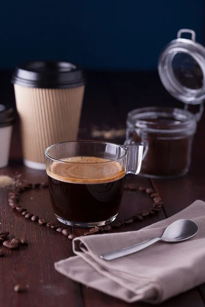 Чорна кава серед зерна кави у формі серця Стокове Фото