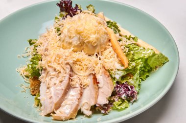 Turkuaz tabakta tavuk sous-vide ile Sezar salatası