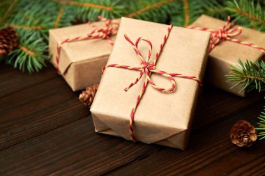 Noel hediyesi kutusunda köknar dalları ve tahta arka planda koniler var. Yakın çekim, seçici odaklanma