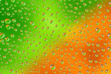 Yeşil turuncu arka planda su damlaları. Üst Manzara. Yakın çekim..