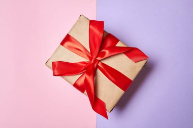 Renkli bir geçmişi olan kırmızı kurdeleli Noel ya da Yeni Yıl hediye kutusu