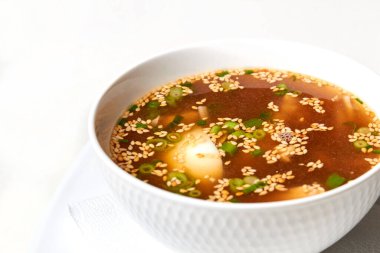 Udon erişte çorbası, tavuk fileto dilimleri, yumurta, yeşil soğanla süslenmiş.