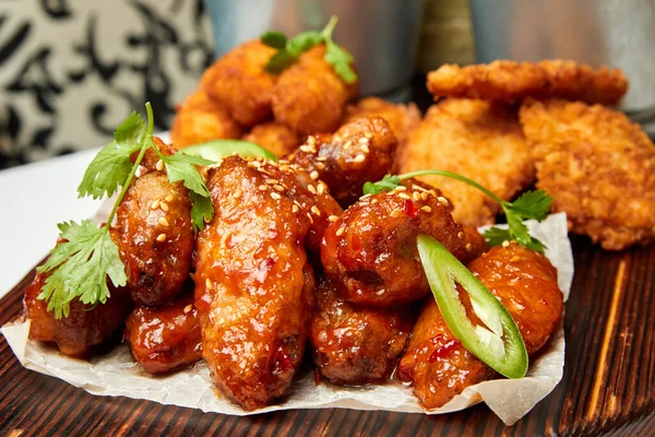 Soslu ve maydanozlu susamlı tavuk kanadı. Yakın çekim, seçici odaklanma