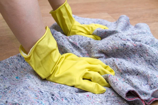 Girl in rubber gloves washes the floor at home with a rag. Concept of housework and housekeeping