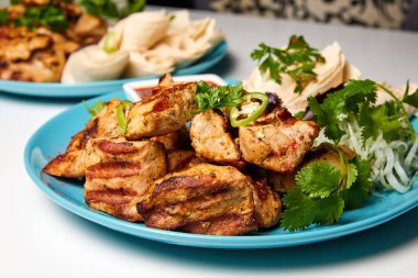 Domuz şiş kebap, lavaş, soğan turşusu ve kırmızı sos.