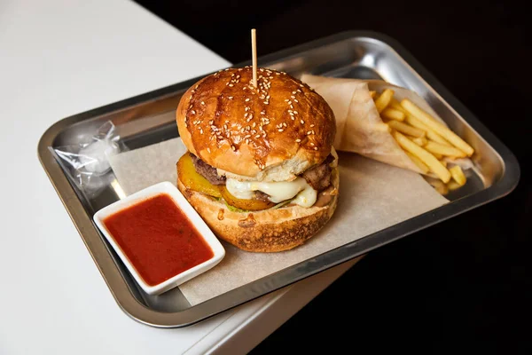 ファーストフードハンバーガーと金属板の上のフライドポテト — ストック写真