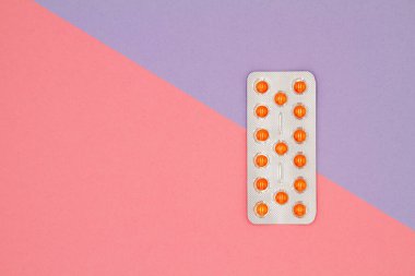 Renkli arka planda su toplamış turuncu hapların üst görüntüsü. Sağlık hizmetleri kavramı.