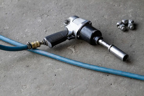 Yedek lastikler için pnömatik anahtar ya da arka bahçe mekaniği çarpma anahtarı yerde yatıyor..