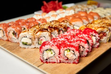 Tahtada bir sürü suşi rulosu var. Yakın çekim, seçici odaklanma