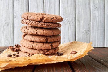 Baharatlı kurabiyeler, parşömen üzerinde kahve çekirdekleri ve ahşap masa.