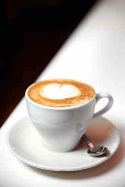 Beyaz bardakta bir fincan Latte kahve. Yakın çekim, seçici odaklanma