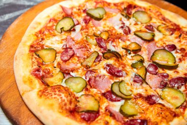 Taze pizza turşusu, pastırma, sosis ve tahta tahtada peynir. Yakın çekim, seçici odaklanma