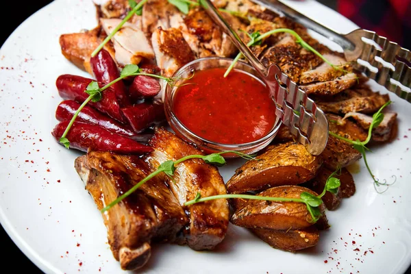 Domuz eti ve tavuk biftekli et, sosis, domuz pirzolası ve kebap soslu. Yakın çekim, seçici odaklanma