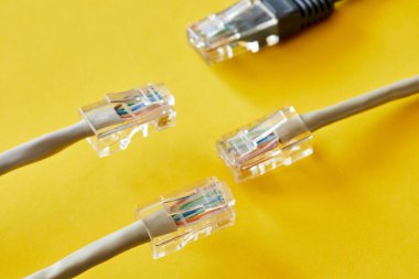 Sarı arka planda RJ45 prizli ethernet kabloları. Yakın çekim, seçici odaklanma