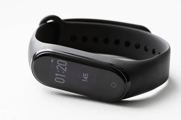 Siyah fitness saati ya da zaman ve adımların gösterildiği aktivite takip cihazı. Fitness takip cihazı beyaz arka planda yatıyor. Yakın çekim, seçici odaklanma