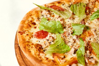 Peynirli pizza, pastırma, domates ve marul. Yakın çekim, seçici odaklanma