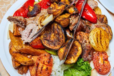 Fırında patates, ızgara sebze, kebap ve sosis. Yakın çekim, seçici odaklanma