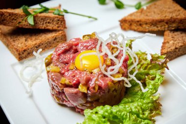 Dana tartarı, bıldırcın yumurtası ve çavdar ekmeği. Yakın çekim, seçici odaklanma