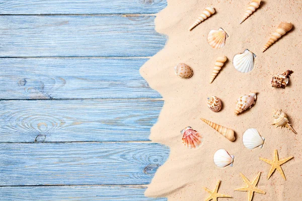 Deniz kabukları ve mavi tahta üzerinde deniz yıldızı olan deniz kumlarından yaz arkaplanı. Kopyalama alanı olan üst görünüm