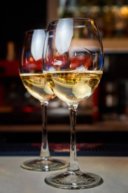 Barın üzerinde iki bardak beyaz şarap. Yakın çekim, seçici odaklanma