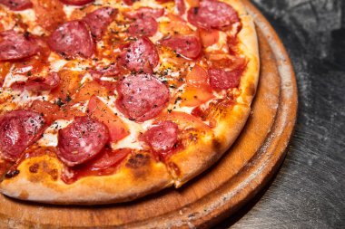 Sosisli, domatesli ve metal tabakta peynirli pizza. Yakın çekim, seçici odaklanma