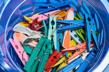Plastik kovada çok renkli mandallar. Yakın çekim, seçici odaklanma