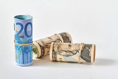 20 Euro 'luk banknot, arka planda duran 20 dolarlık banknotlar şeklinde yuvarlandı. Avro üstünlüğü kavramı doların üstündedir. Yakın çekim, seçici odaklanma