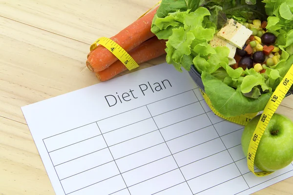 Feuille de plan de régime et produits frais sur table en bois — Photo